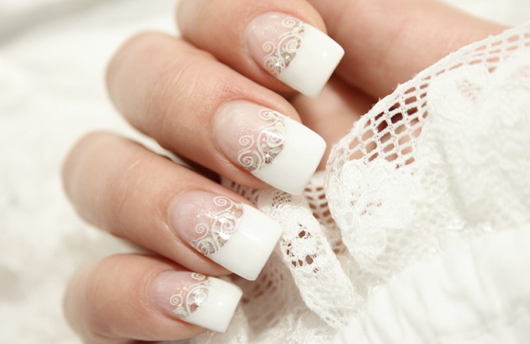 Unghie belle, french manicure donna con decorazioni effetto pizzo e piccoli brillantini 